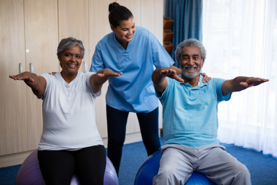 caregiver guiding seniors in exercising at retirement home